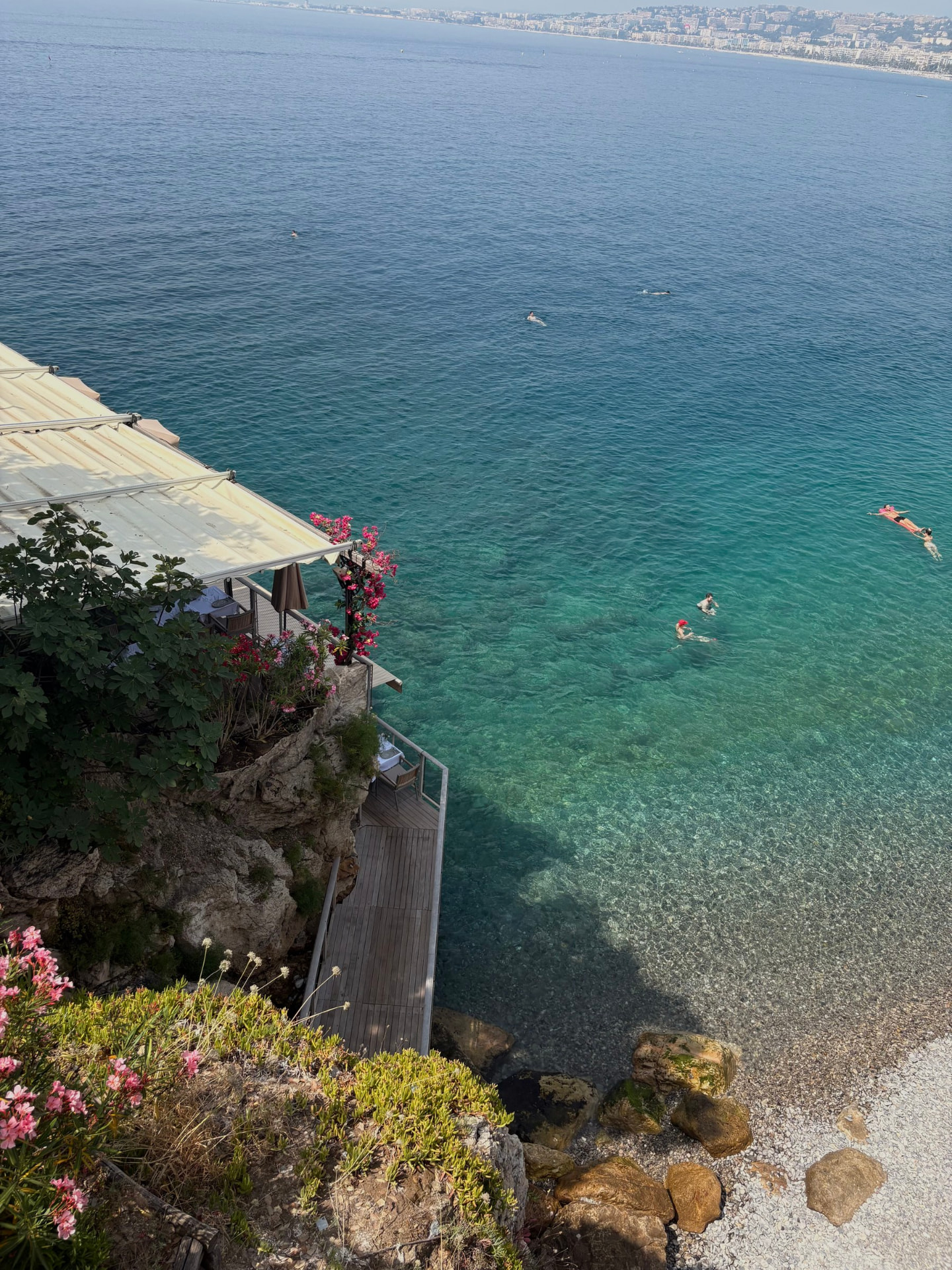 A clifftop restaurant terrace above clear turquoise water