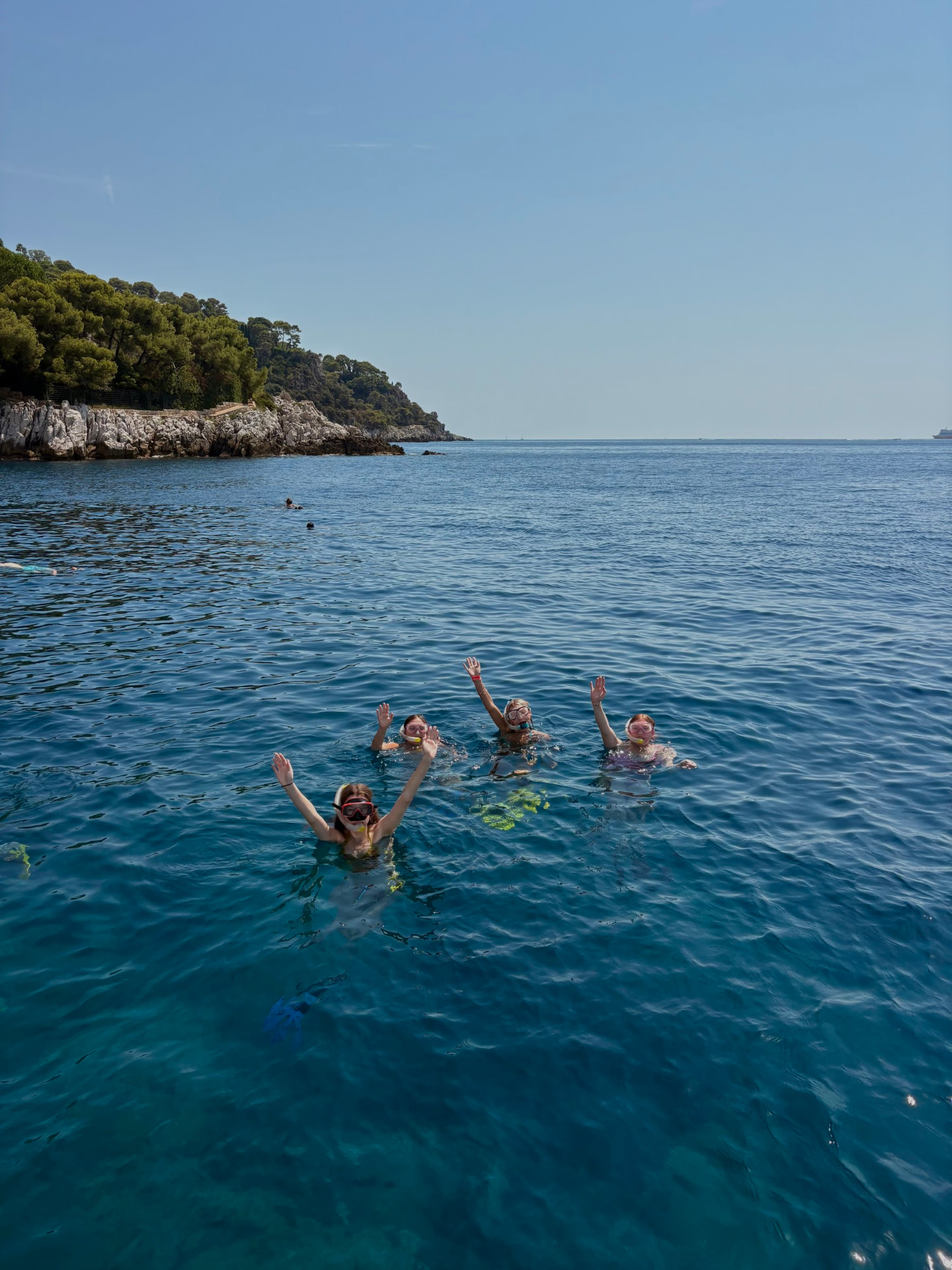 Friends swimming and waving together in deep blue water
